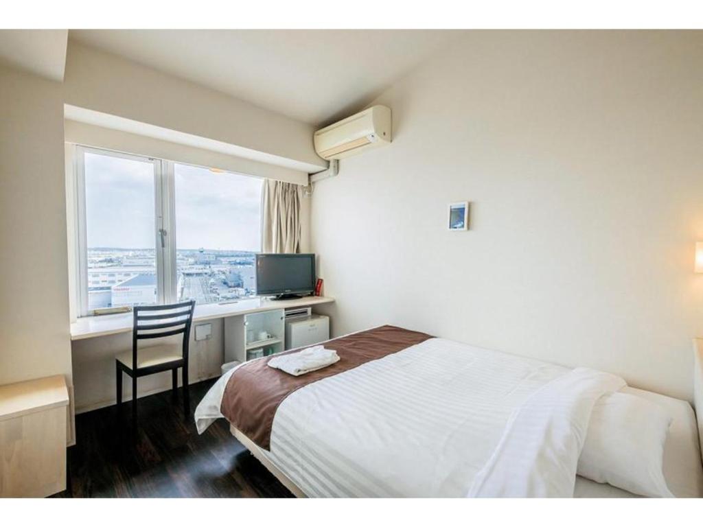 丰见城市HOTEL GranView Garden OKINAWA - Vacation STAY 44967v的一间卧室配有一张床、一张书桌和一个窗户。