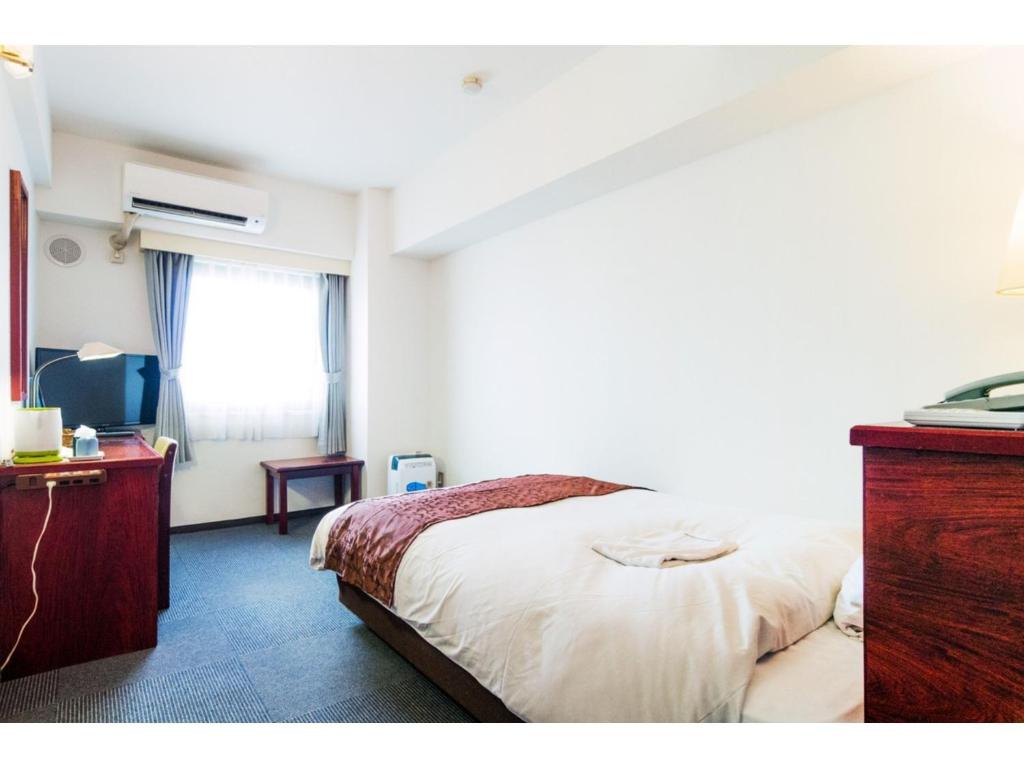 东京Sky Heart Hotel Koiwa - Vacation STAY 49100v的一间卧室配有一张床、一个梳妆台和一扇窗户。