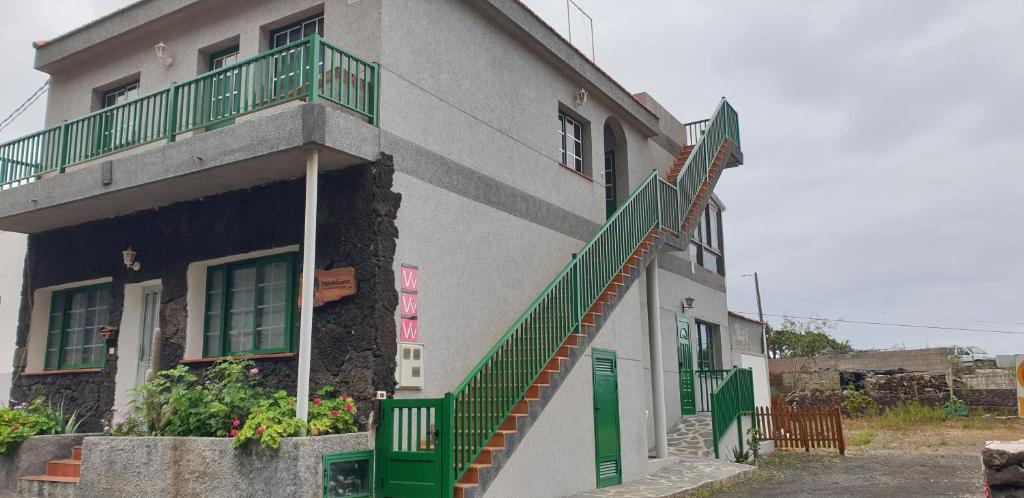 Las PuntasVivienda Vacacional Meridiano的一座带绿门和楼梯的建筑