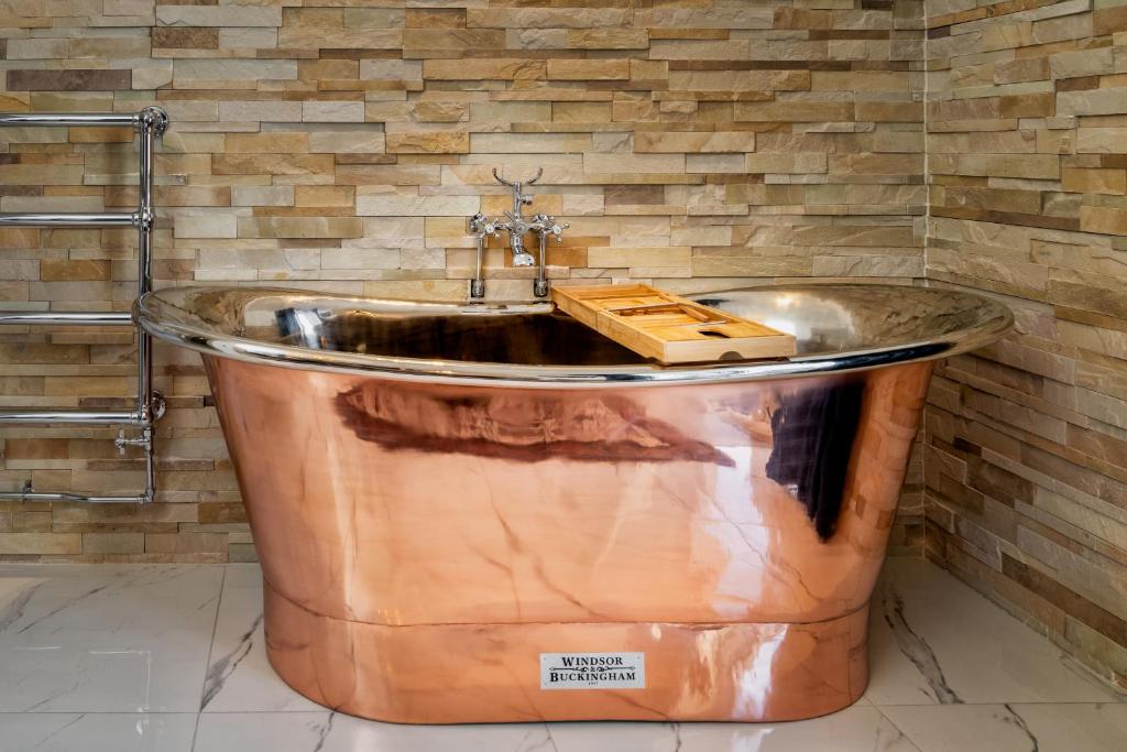 因弗内斯Relax in Super Size Copper Tub - 2 bedroom villa的一个带水槽的浴室内的大型铜浴缸