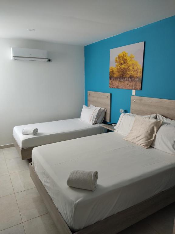 巴耶杜帕尔Escala Hotel的蓝色墙壁客房的两张床