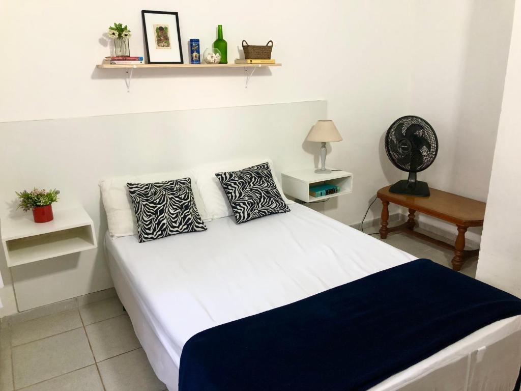 皮拉西卡巴Casa com ótima localização的客房内的一张带两个枕头的白色床