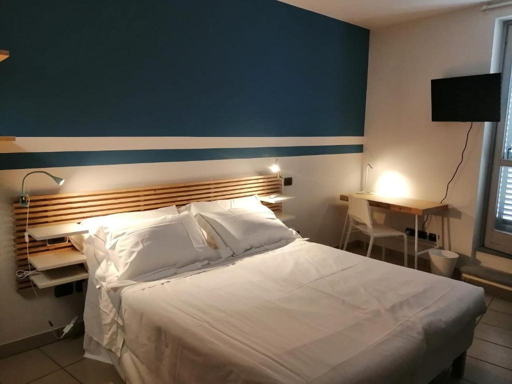 蒙多维Albergo della Posta的一间卧室配有一张白色大床和蓝色的墙壁