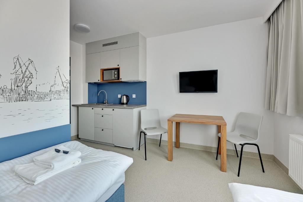 格丁尼亚Apartgdynia的客房设有床、桌子和微波炉。