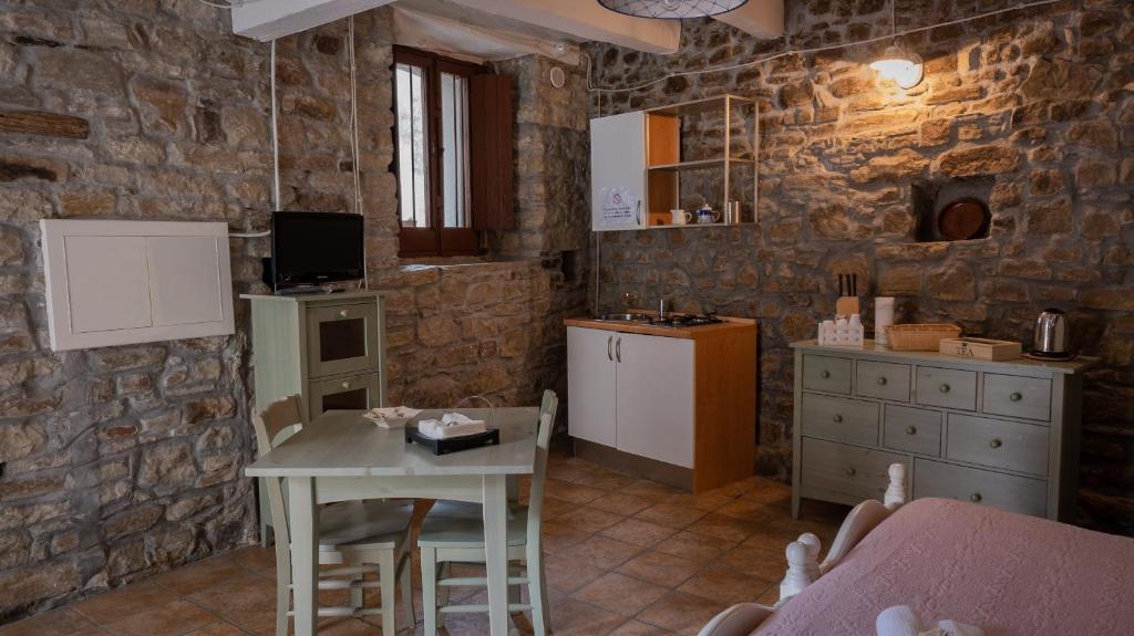 皮耶特拉佩尔托萨Il Rifugio di Bomar的厨房以及带桌椅的用餐室。