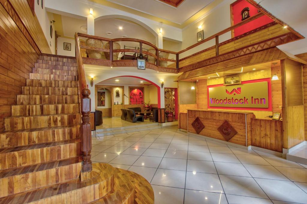 马拉里Woodstock Inn Manali的大楼内有楼梯的餐厅的大堂