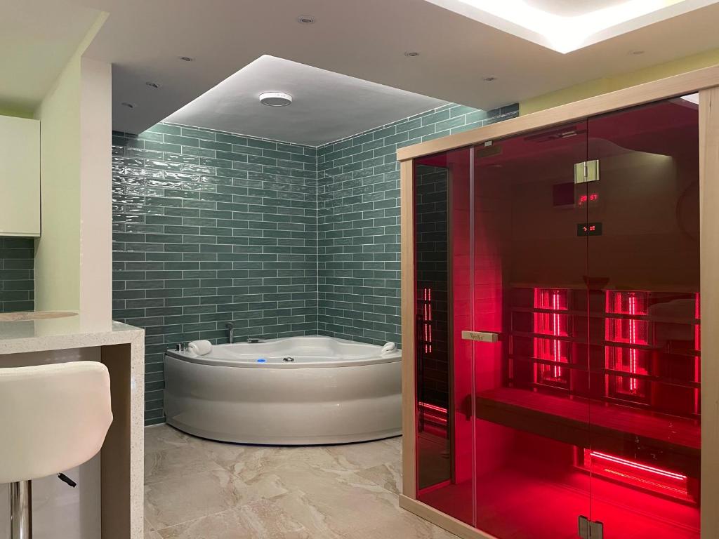 弗尔尼亚奇卡矿泉镇Spa apartman Sobhe的浴室配有浴缸和红灯淋浴