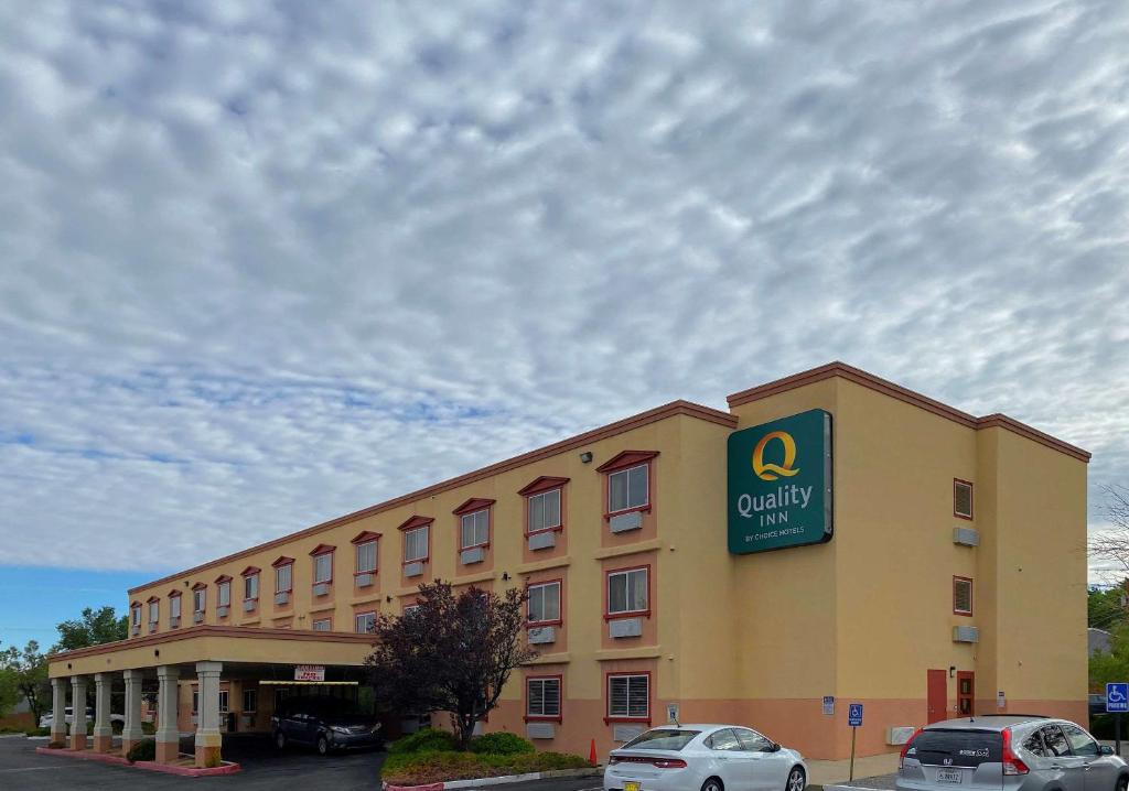 阿尔伯克基Quality Inn Albuquerque East I-40 Juan Tabo Exit的一座黄色的大建筑,上面有标志