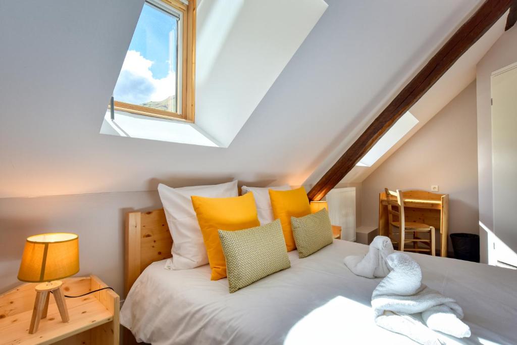 瓦卢瓦尔Hôtel Les Essarts, USSIM Vacances的一间卧室配有一张带黄色枕头的床和一扇窗户