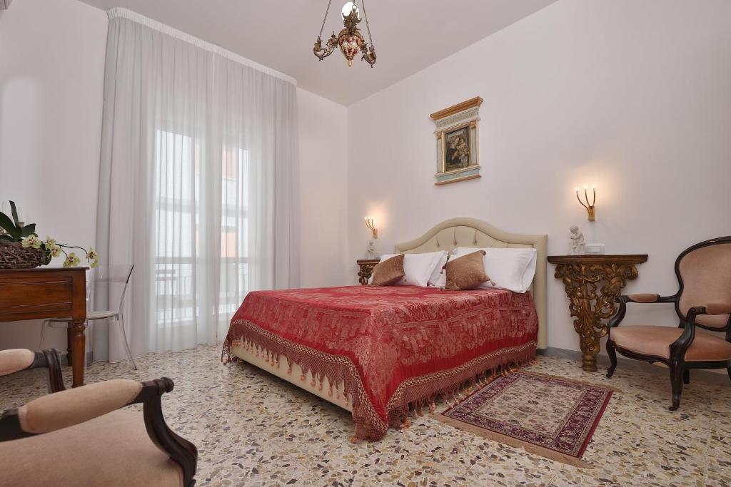 米诺利Casa Real的一间卧室配有红色的床和椅子