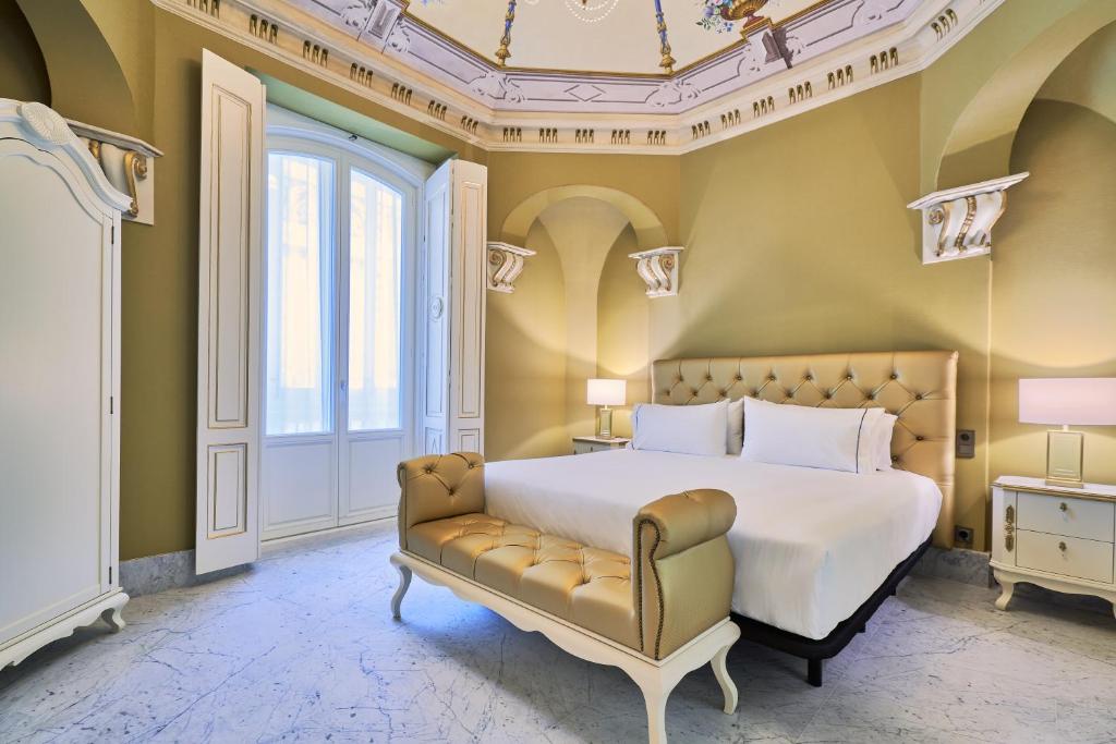 加的斯Tandem Palacio Veedor de Galeras Suites的一间卧室配有一张床和一张沙发