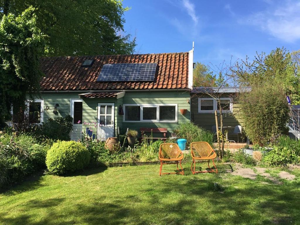 佐伊杜比斯特Beemster Tiny House的一个带两把椅子的院子和一个带太阳能屋顶的房子