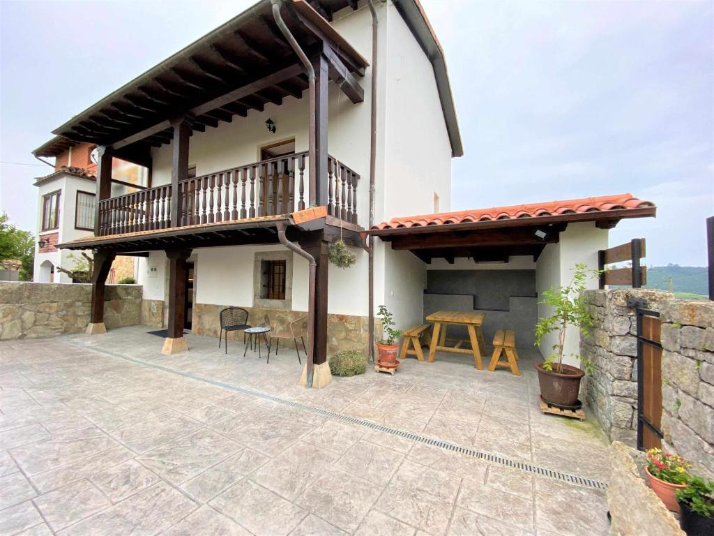 科隆布雷斯La Finca de Ribadedeva的度假屋设有阳台和天井桌子