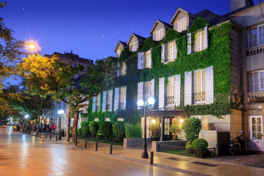圣地亚哥梦想精品酒店的一座在晚上被青春常春藤覆盖的建筑