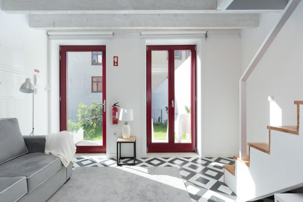 波尔图Loureiro Villas的客厅设有白色的墙壁和红色的门