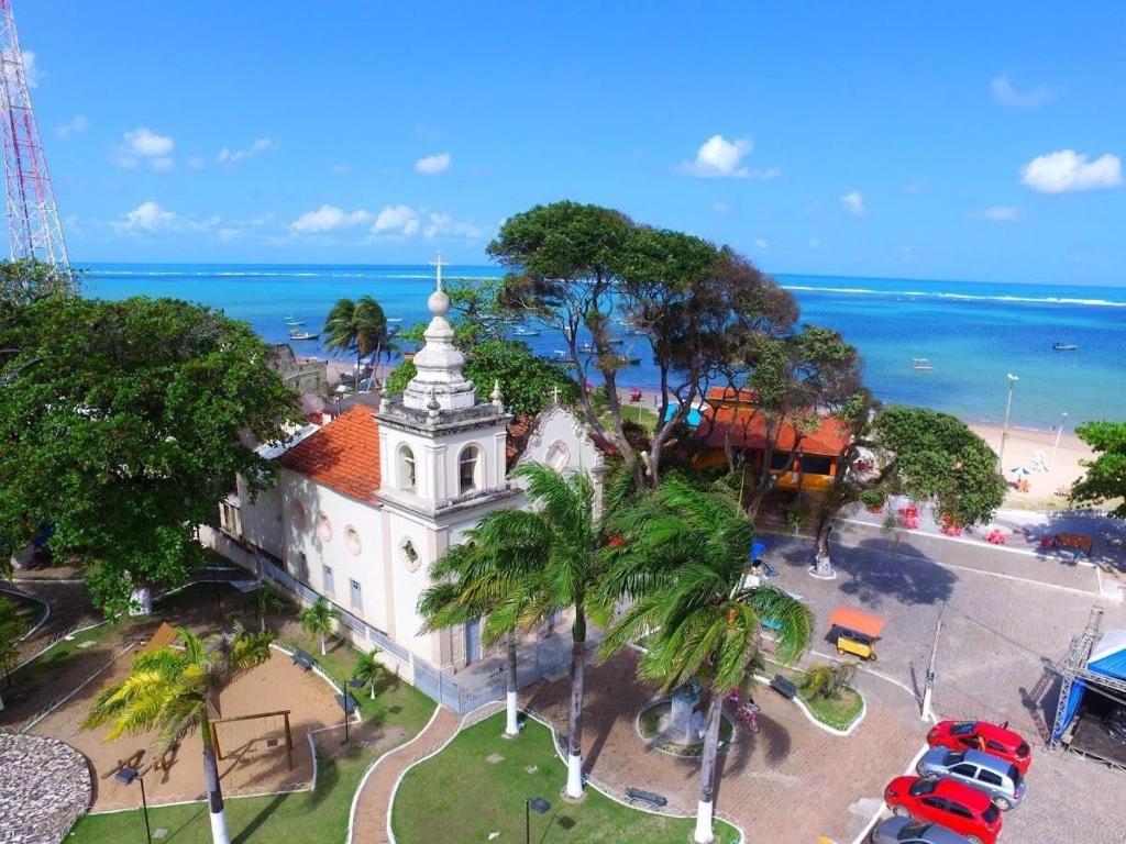 圣若泽-达科罗阿格兰迪Lindo Flat Mar Azul em São José da Coroa Grande, Pernambuco的海洋前教堂的空中景观
