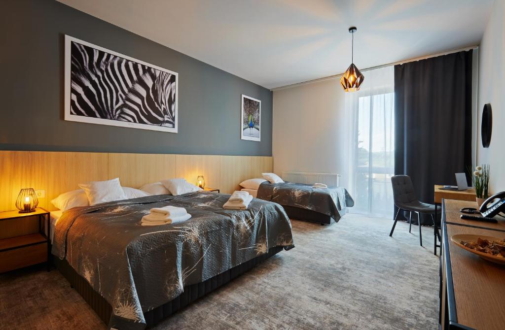 科希策Hotel & Restaurant Barca的酒店客房配有两张床和一张书桌