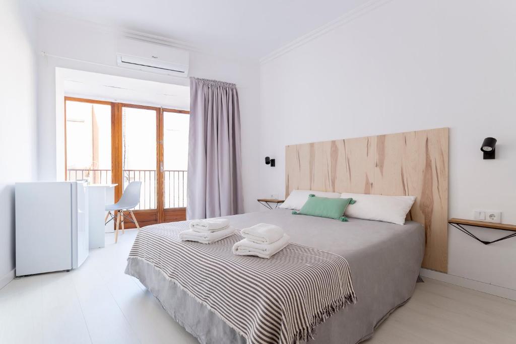 阿利坎特Casa M&J GuestHouse的一间卧室配有一张大床和两条毛巾