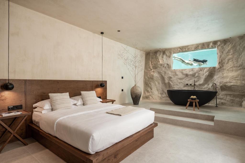 帕利乌里翁Seven Rocks的一间卧室设有一张大床和一个浴缸