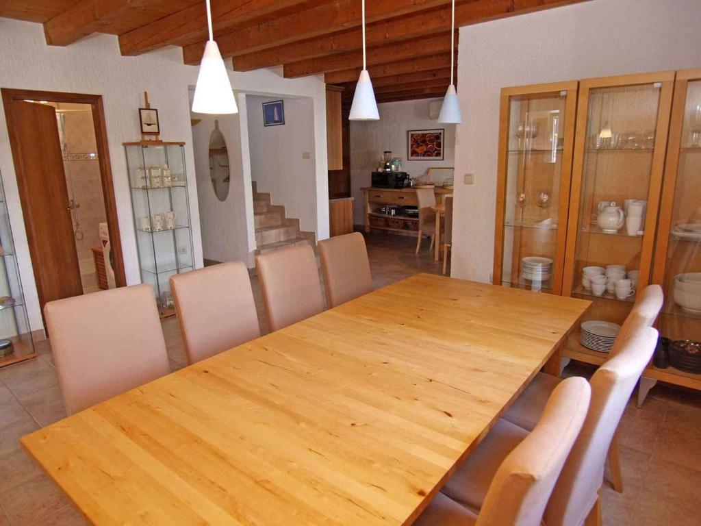 大洛希尼Holiday home in Veli Losinj 36387的一间带木桌和椅子的用餐室