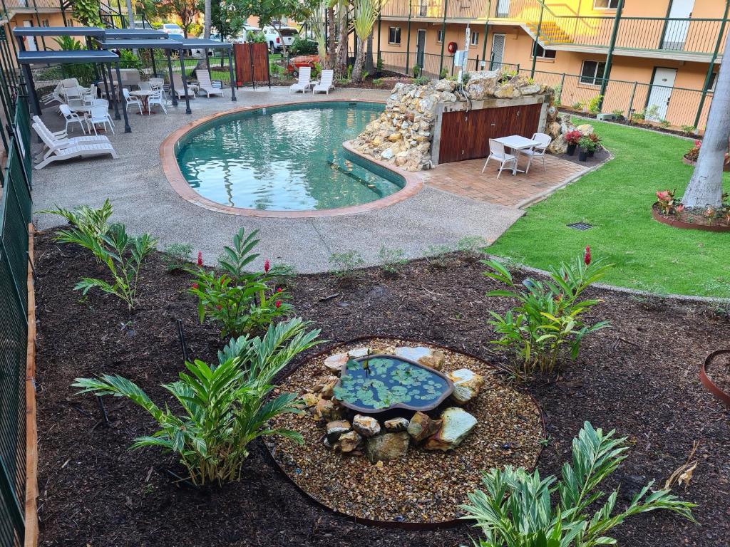 达尔文阿勒泰假日公寓酒店的后院设有带桌椅的游泳池