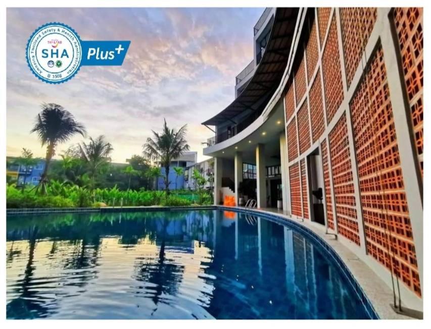 奈扬海滩Atom Phuket Hotel -SHA Plus的大楼前的游泳池