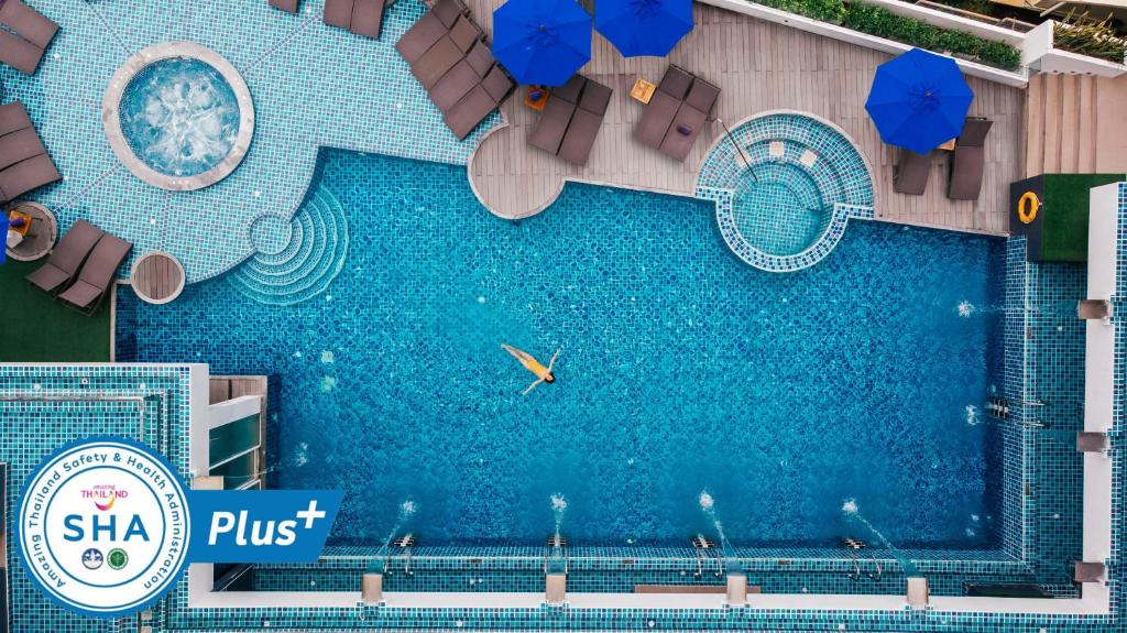卡塔海滩The Yama Hotel Phuket - SHA Extra Plus的享有带遮阳伞的游泳池的顶部景致