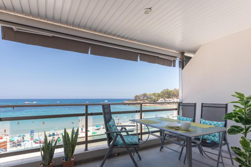卡尔佩Apartamento Frentemar 2 - Costa CarpeDiem的阳台配有桌椅,享有海滩美景。