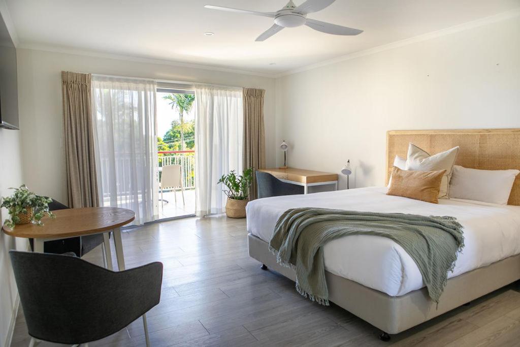 努萨角努萨海兹汽车旅馆的一间卧室配有一张床、一张桌子和一个窗户。