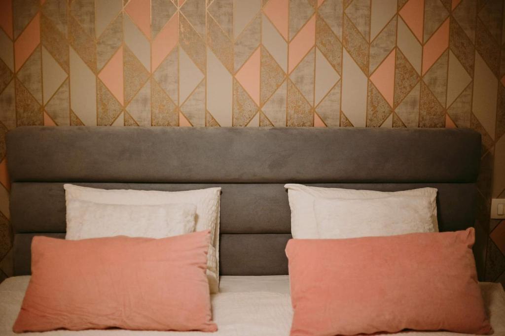 斯拉沃尼亚布罗德Apartman Gold的墙上一张带两个枕头的床