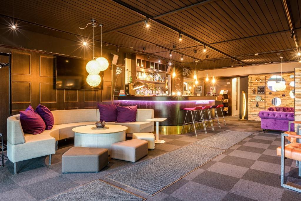 豪基普达斯Samantta Hotel & Restaurant的带沙发的大堂和带紫色家具的酒吧