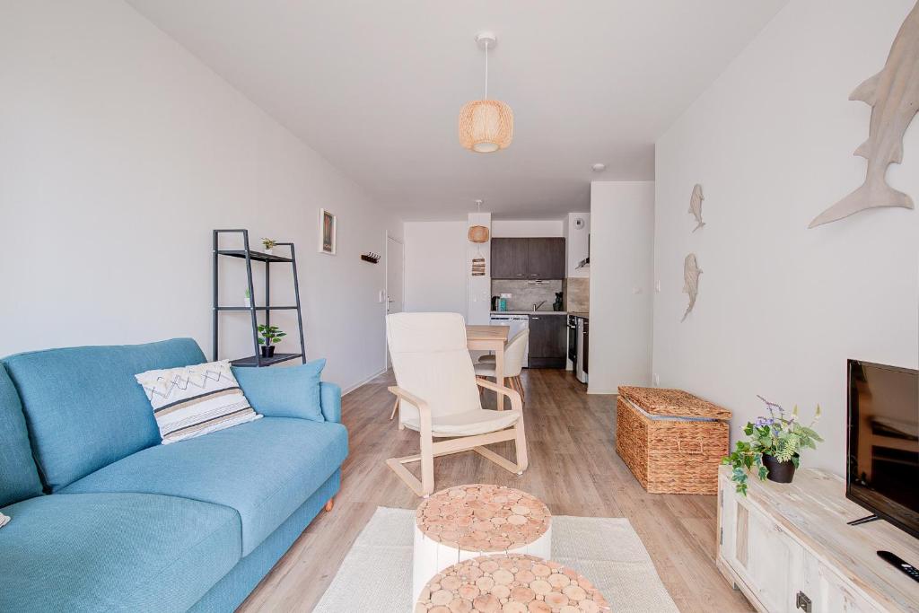 拉卡诺Ressourcez vous dans ce bel appartement a Lacanau的客厅配有蓝色的沙发和桌子