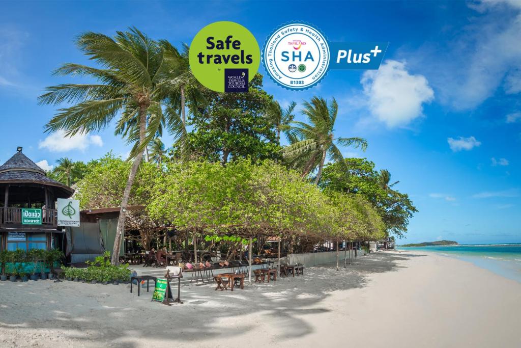 查汶Chaweng Garden Beach Resort - SHA Plus的海滩上摆放着桌椅,标牌上写着安全旅行的标牌