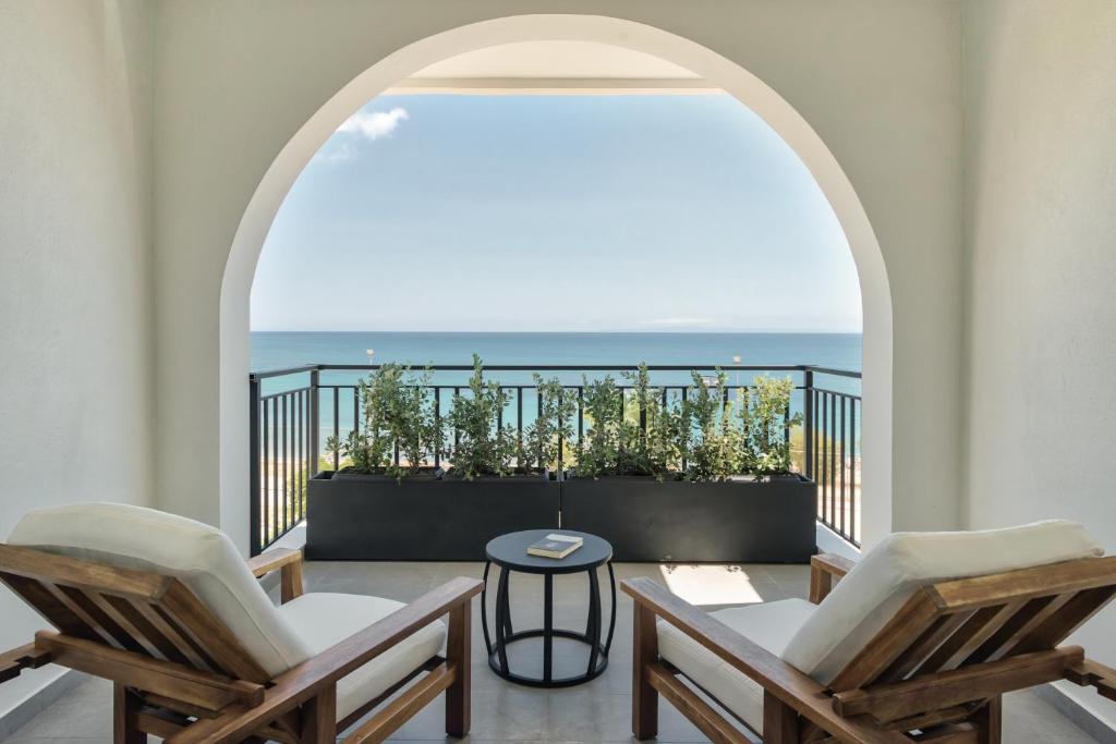 扎金索斯镇Bitzaro Boutique Hotel的阳台配有两把椅子,享有海景。