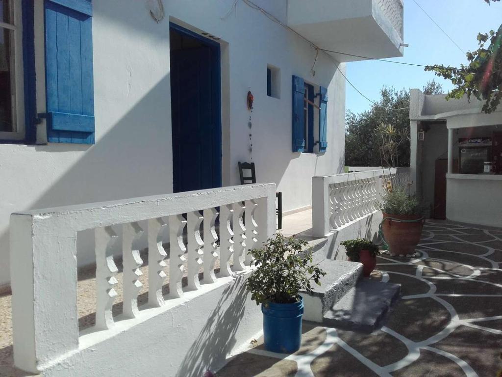 雷夫科斯卡尔帕索Nikos Taverna and Apartments的白色的房子,有长凳和蓝色的门