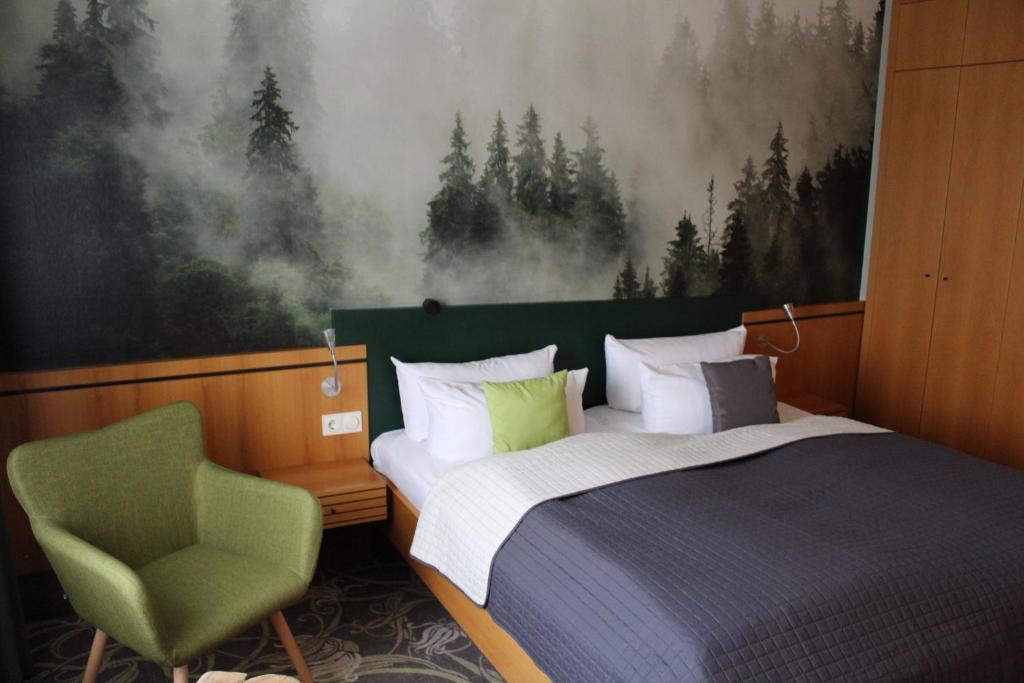 马瑟尔贝格林思特格酒店的一间卧室配有一张床和一把绿色椅子