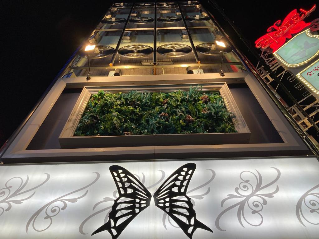 大阪ホテル チョウ 十三的两个蝴蝶站在花园前