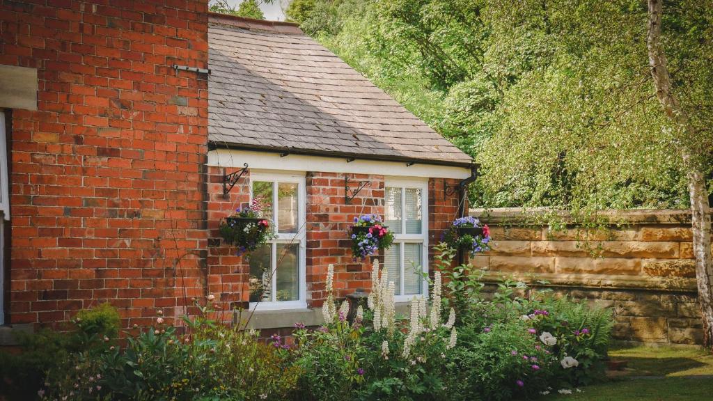 Bardon MillRiver Cottage at Old Post Office的窗户上花的红砖小房子