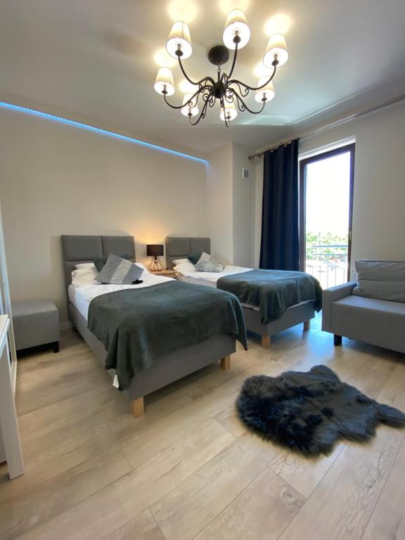 扎维尔切Aparthotel Riva的一间卧室配有两张床和吊灯。
