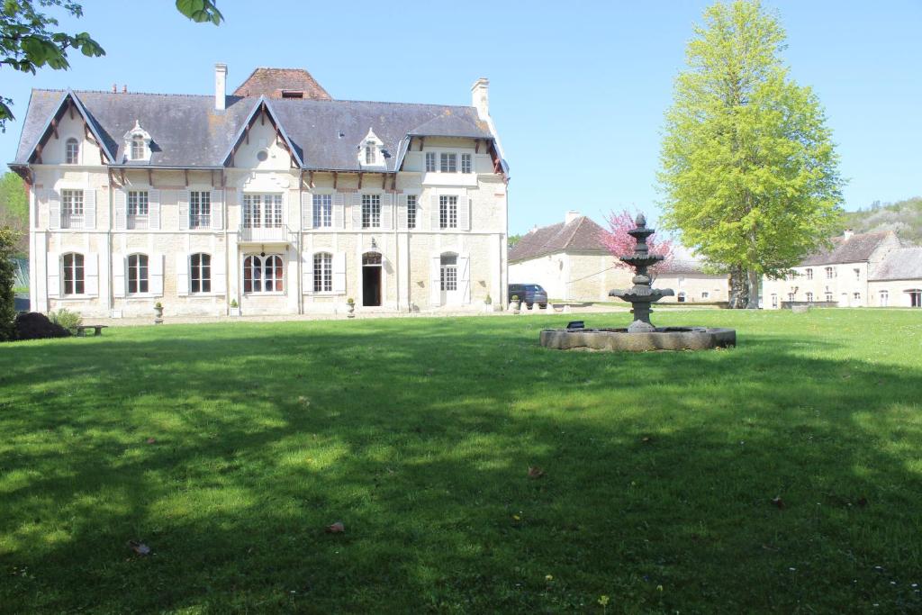 DamblainvilleChâteau du Mesnil Soleil , gites et chambres d'hôtes的一座大白色房子,在院子里设有一个喷泉