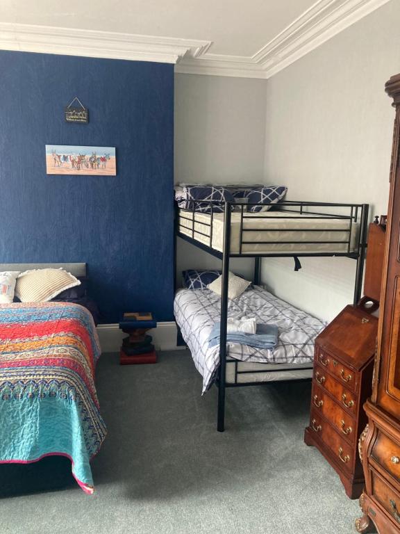 布里德灵顿Greyfriars Guest House的一间卧室设有两张双层床和蓝色的墙壁
