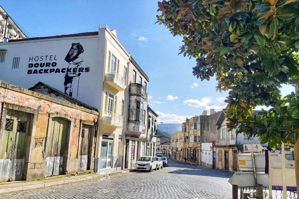 皮尼昂Hostel Douro Backpackers的路边停有车辆的镇上街道