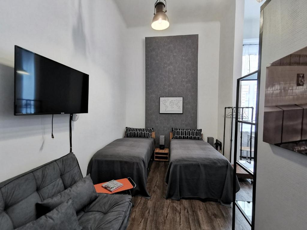 林茨Industrial Studio am Neuen Dom的一间带两张床和一张沙发的客厅