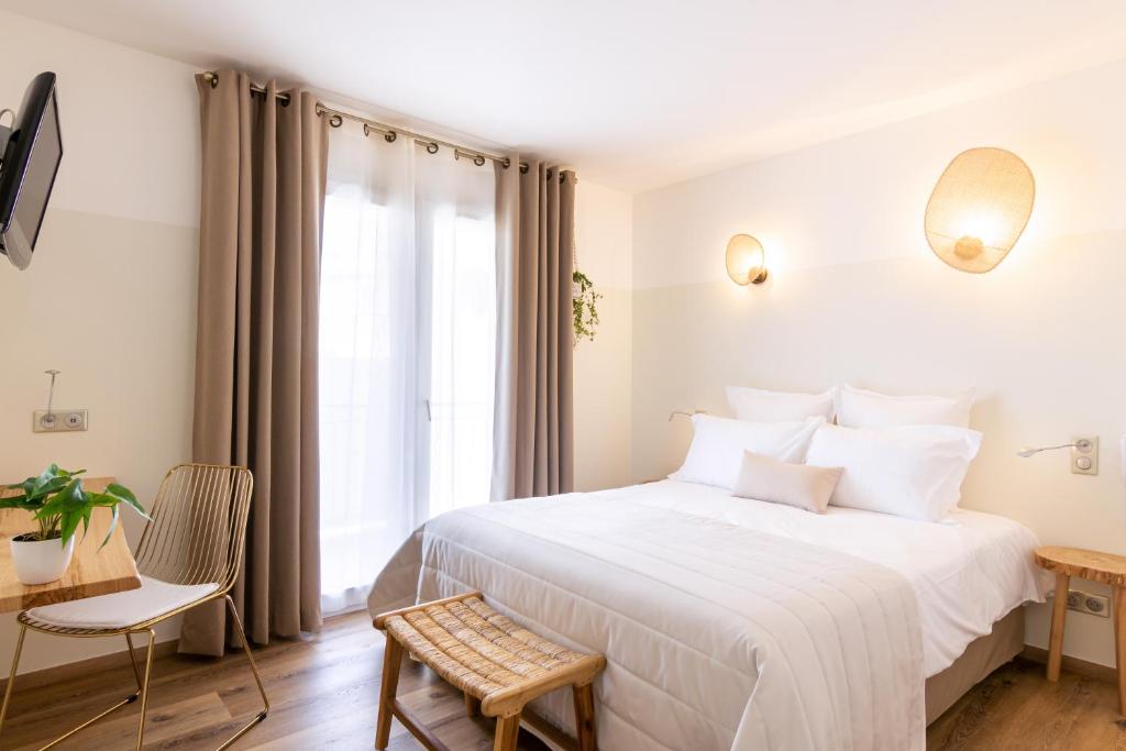 圣弗洛朗Hôtel Flor的卧室配有一张白色大床和一张书桌