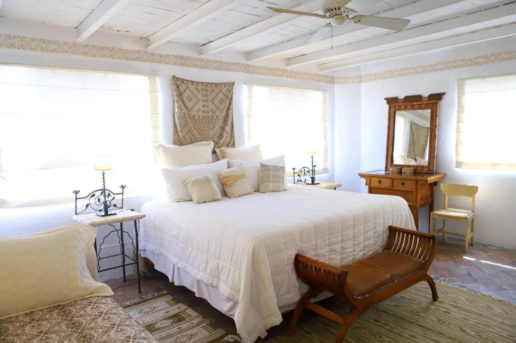 圣米格尔-德阿连德圣多明哥套房公寓式酒店的卧室配有白色的床和椅子