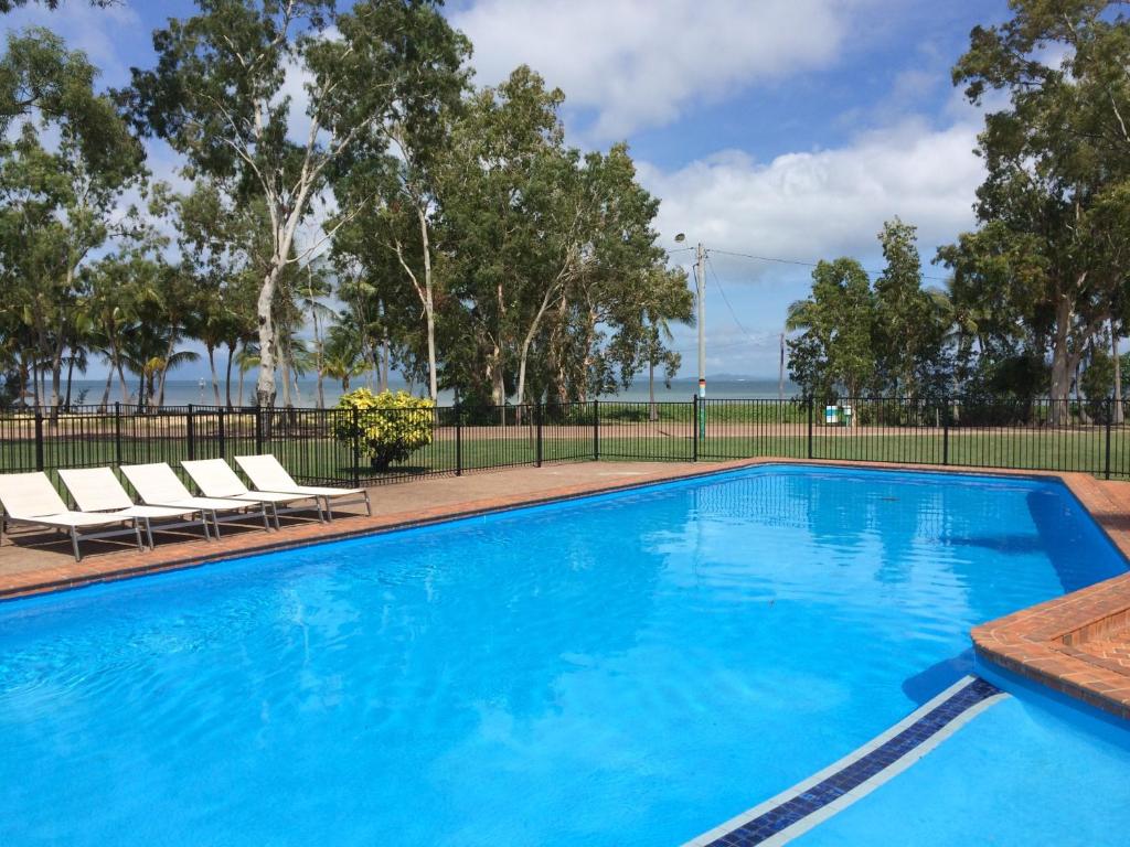阿卡狄亚阿卡迪亚村莫泰酒店的一个带两把躺椅的游泳池,围栏旁