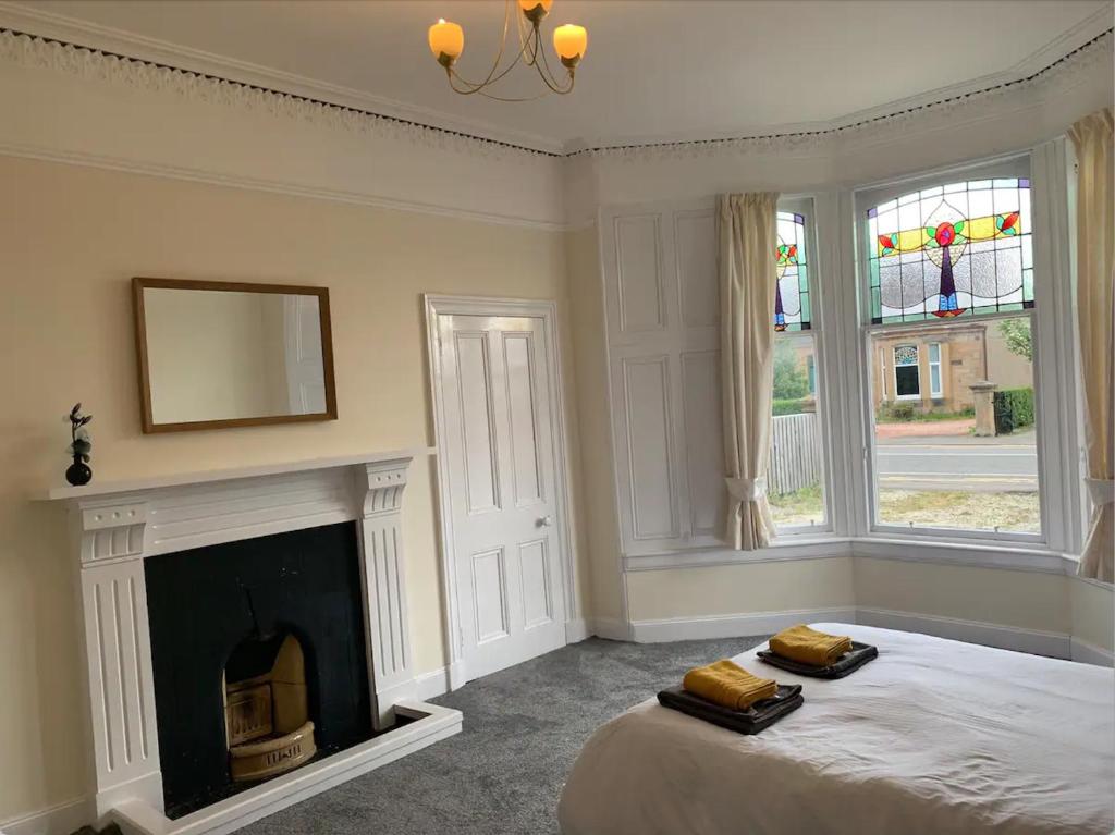 福尔柯克Grangemouth Apartments的一间卧室配有一张带壁炉和镜子的床