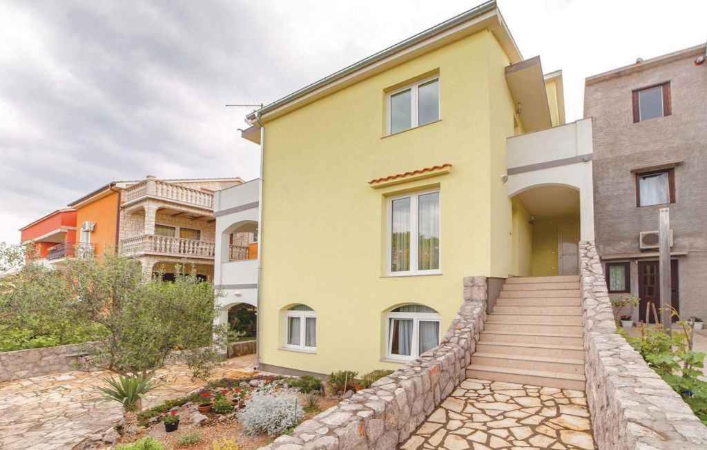 克拉列维察Two-Bedroom Apartment in Kraljevica II的黄色的房子,设有石墙和楼梯