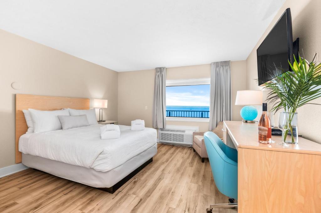 特拉弗斯城Gold Coast Inn的酒店客房配有一张床、一张书桌和一台电视。