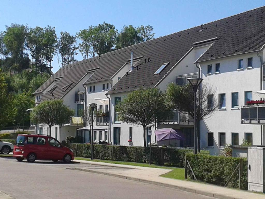 宾茨Apartment in Binz (Ostseebad) 2864的停在一排房子前面的一辆红色汽车